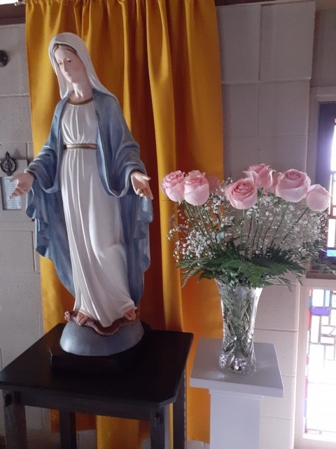 Staure of Mary with pink roses in the sanctuary